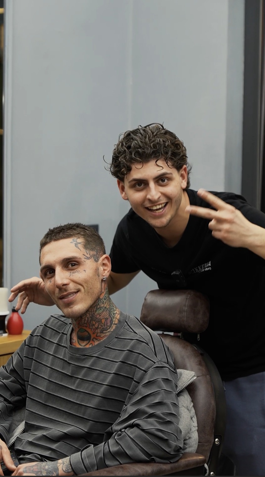 Francesco accanto a un cliente in barberia
